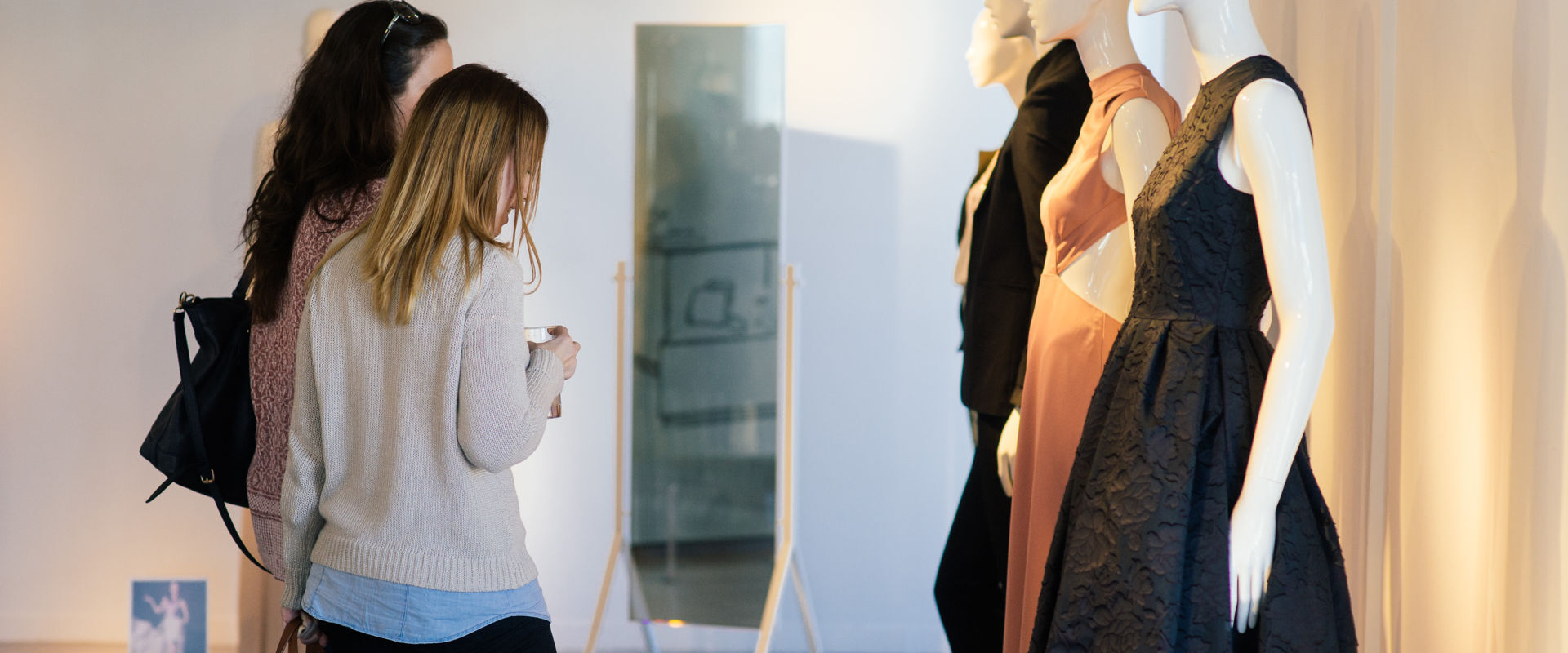 Women gazzing at designer dresses