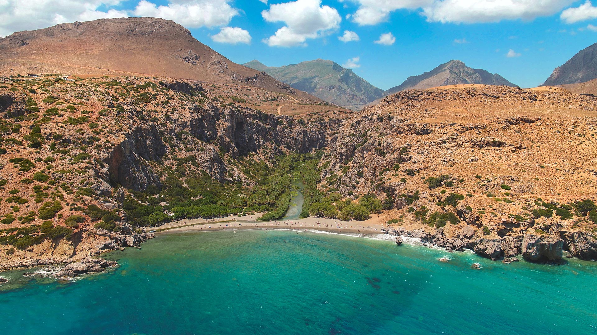 Preveli beach, with its palm grove, saltwater lagoon and dramatic Cretan gorge as scenery
