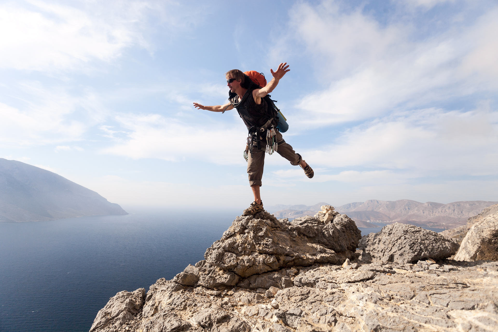 Jeune homme debout sur un rocher contre une vue pittoresque sur la mer