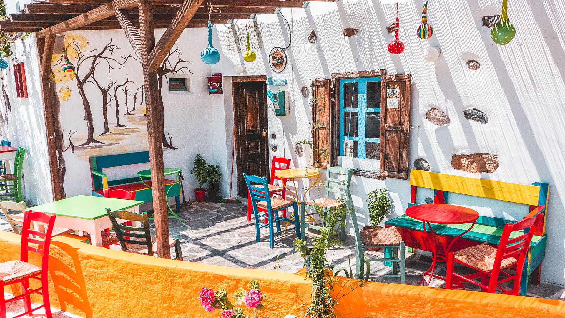 Whitewashed houses, blue windows, flowery courtyards and colorful cafes in Maltezana village, Astypalea