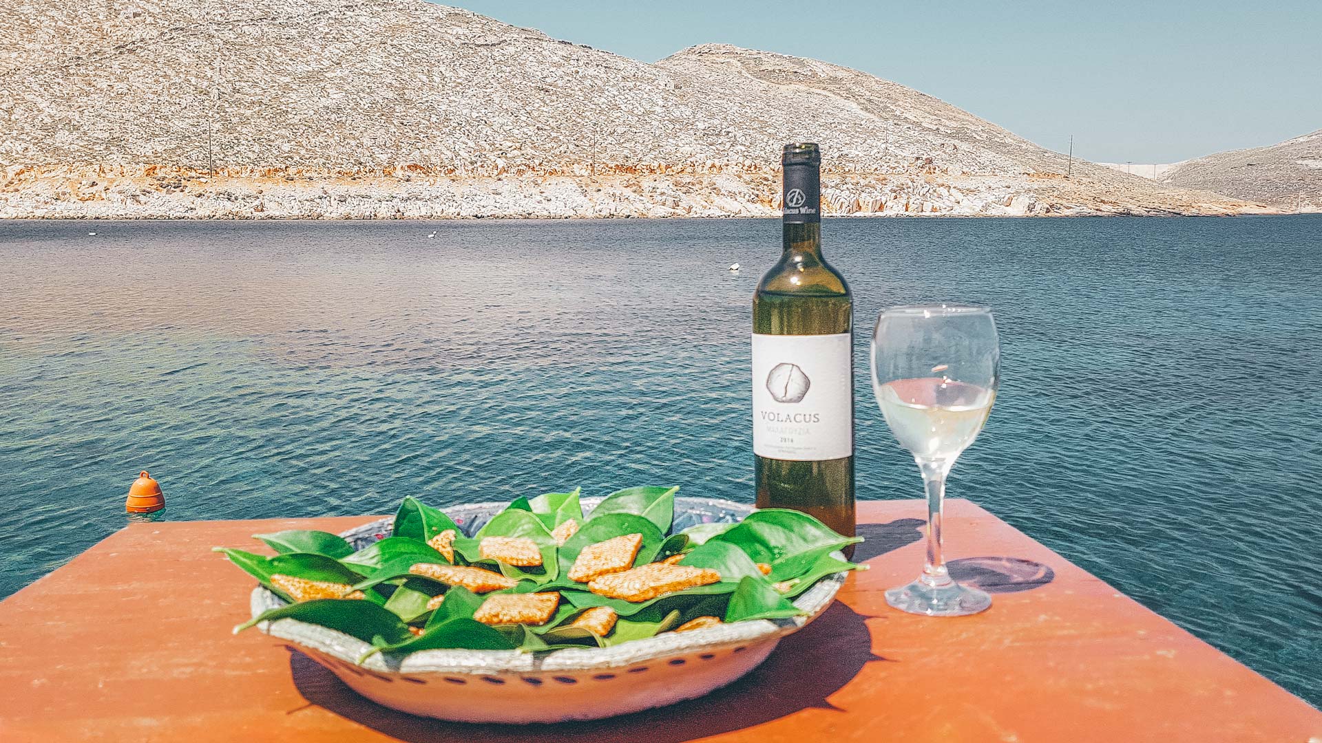 Pasteli with local honey, served in lemon leaves with local white wine (Malagouzia or Assyrtiko variety)