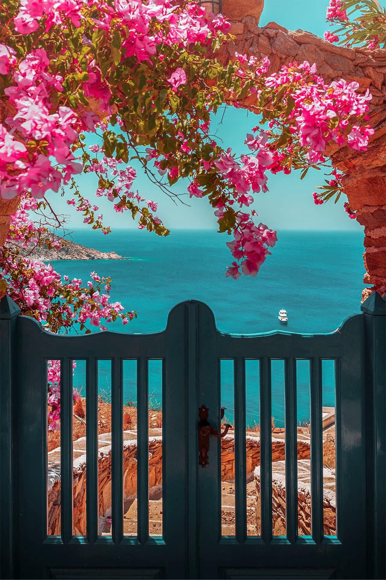 Picturesque bougainvillea and a door leading to a beautiful beach, on Ios island