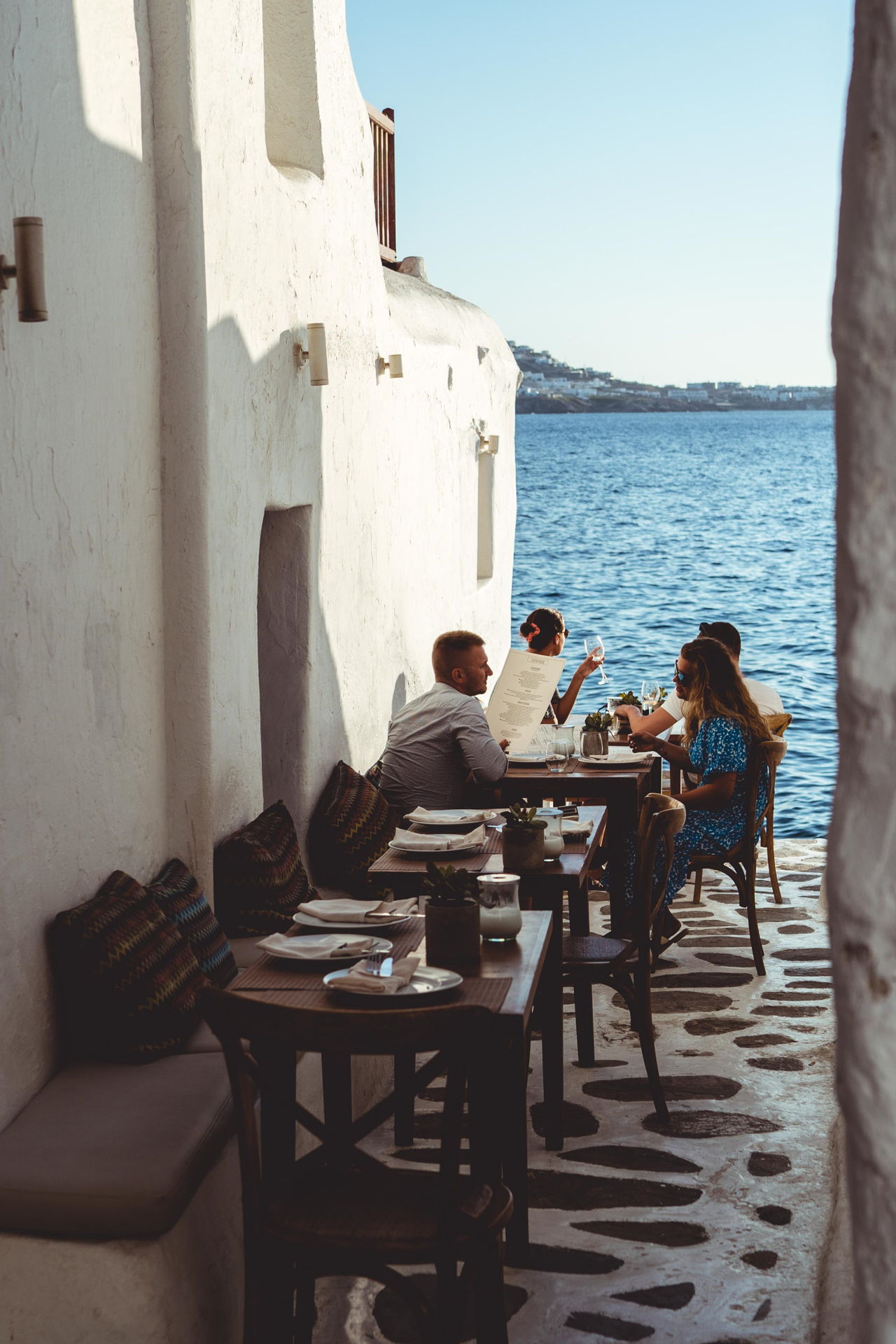 Dining in Cycladic alleyway by the sea in Mykonos.