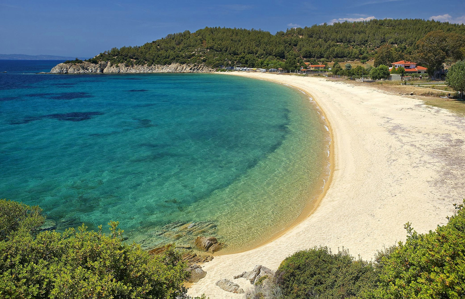 Kristallklares, türkisfarbenes Gewässer eines paradiesischen Strandes in Halkidiki