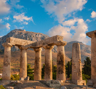 Ruins of Appollo temple with fortress at back in ancient Corinth