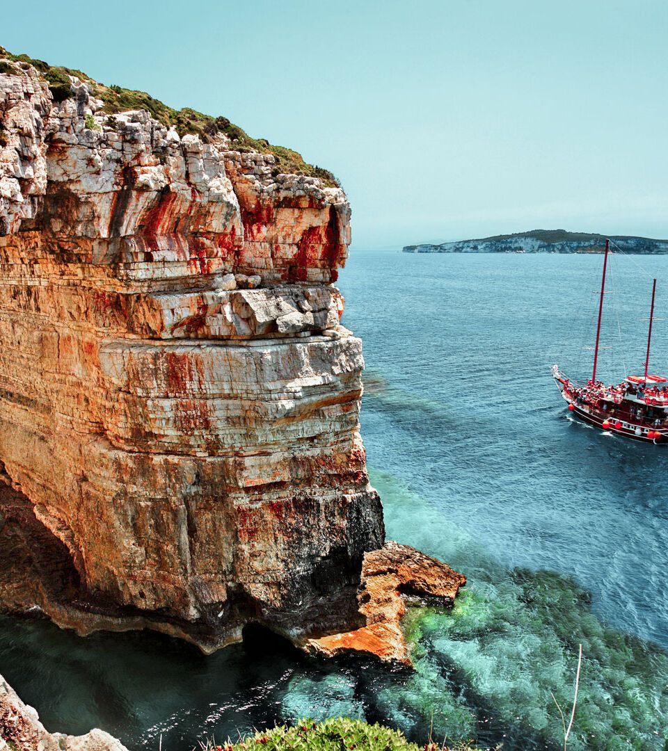 Boat passing next to Trypitos (also known as Kamara), a natural rocky arch at Paxos island