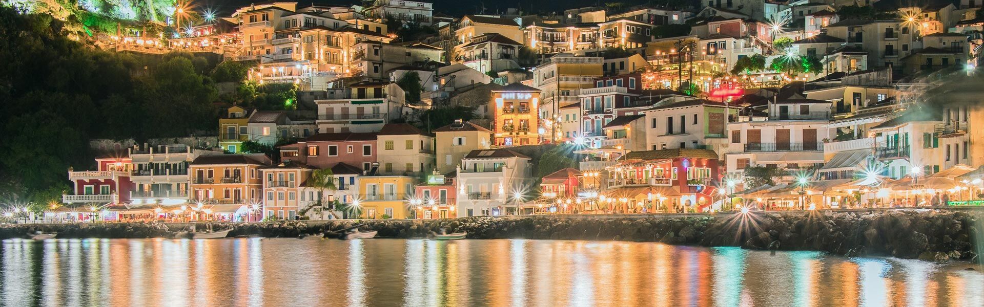 Looking across the bay towards traditional houses and Parga's castle, during the night