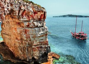 Boat passing next to Trypitos (also known as Kamara), a natural rocky arch at Paxos island