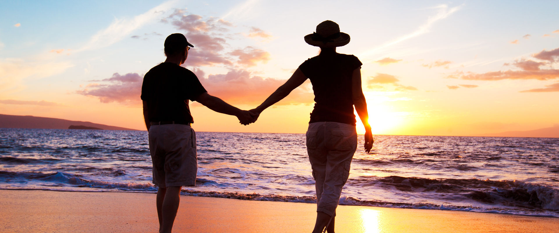Paare, die Sonnenuntergang am Strand genießen