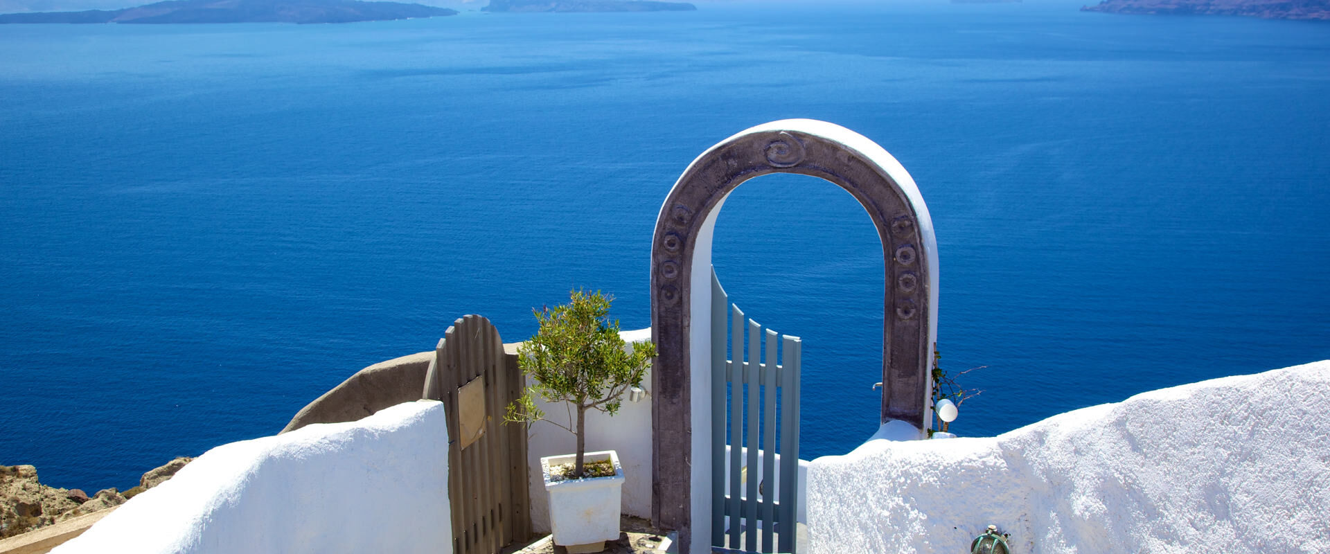 Open door beside the Aegean sea with green plants beside