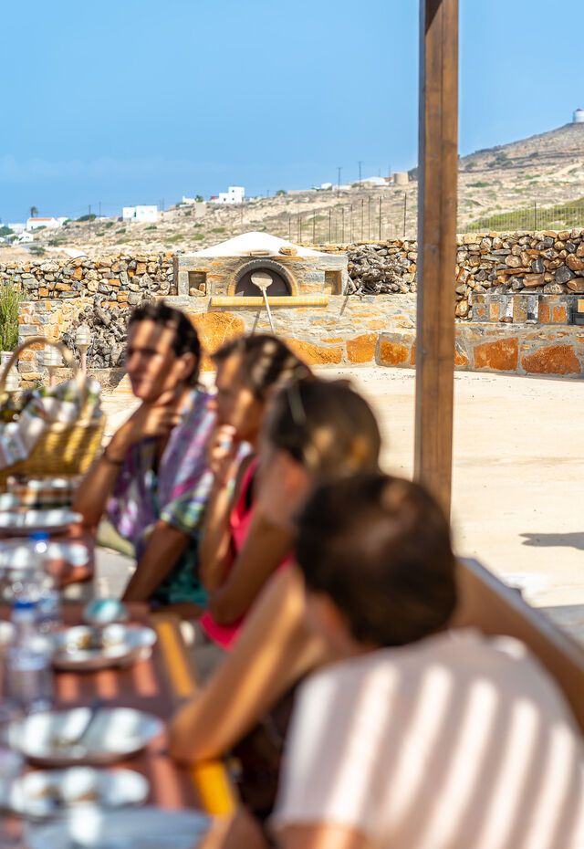 Focused shot of traditional food items and a stone oven in the background, emphasizing Kasos Island's culinary heritage.