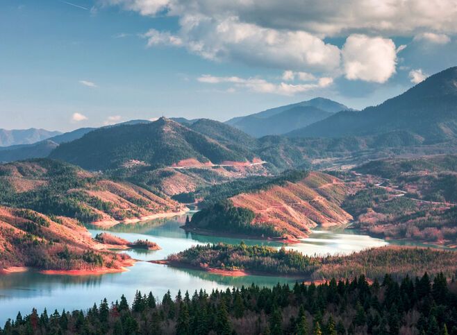 The beauty of its waters, reflecting the imperious peaks of the Agrafa range