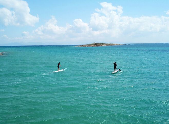 Aerial photo of competition sport paddle surfing or sup between 2 men in tropical waters of Vouliagmeni beach, Athens riviera, Attica, Greece