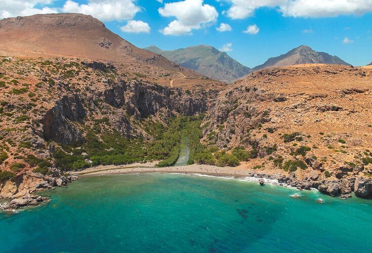 Preveli beach, with its palm grove, saltwater lagoon and dramatic Cretan gorge as scenery