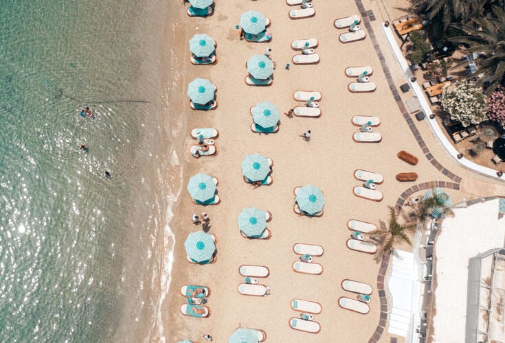 The fine white sand of Psarou beach in Mykonos in early summer months