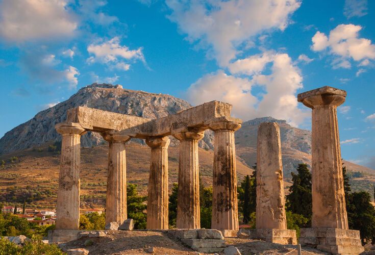 Ruins of Appollo temple with fortress at back in ancient Corinth