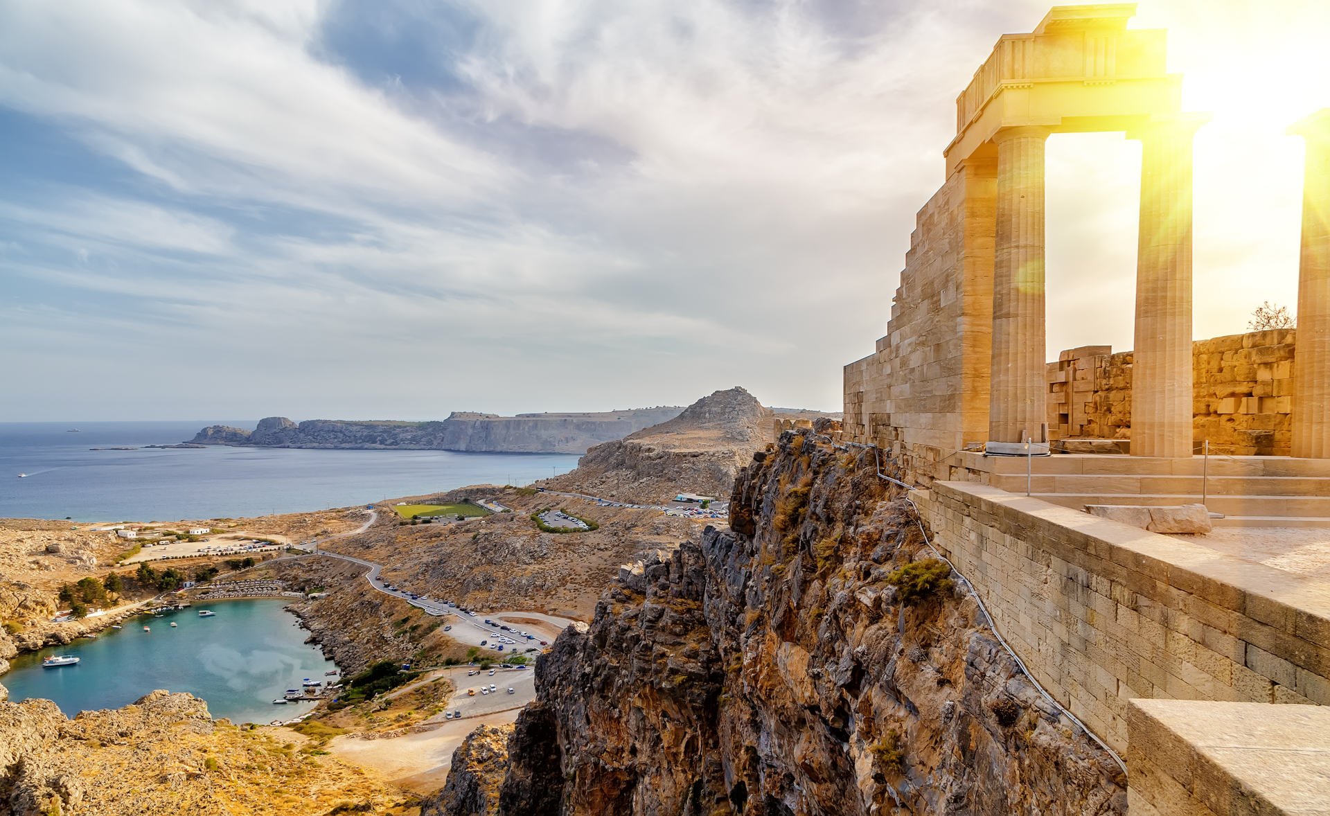 Acropolis of Lindos. Doric columns of the ancient Temple of Athena Lindia setting sun above the columns  T
